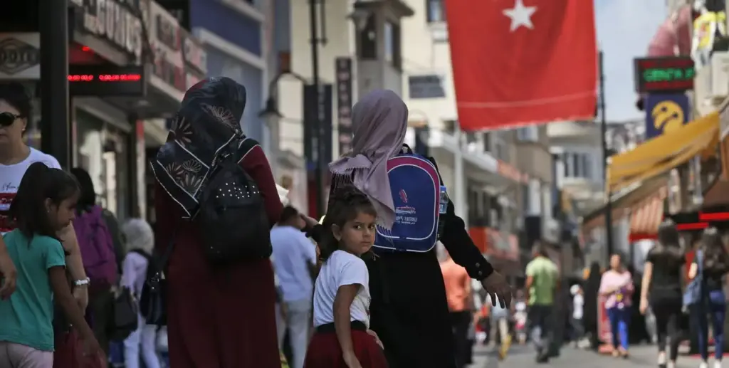 A Turkish flag hangs above a busy street in Turkey.